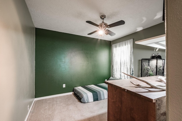 bedroom featuring a textured ceiling, carpet floors, and ceiling fan