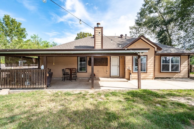 rear view of house with a lawn and a patio