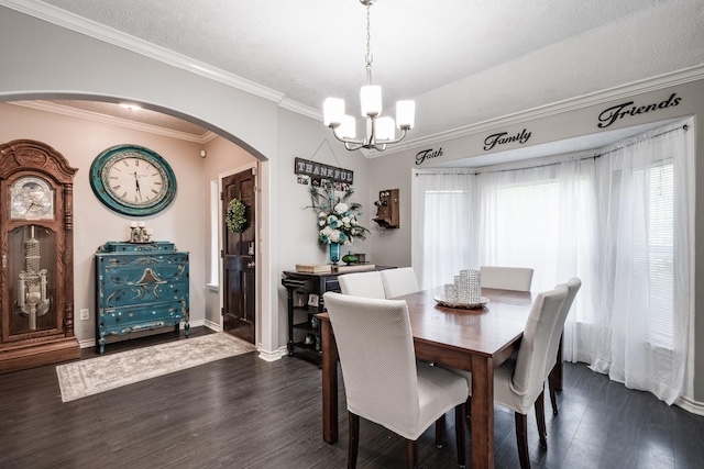 dining area featuring crown molding, dark wood-type flooring, and a notable chandelier