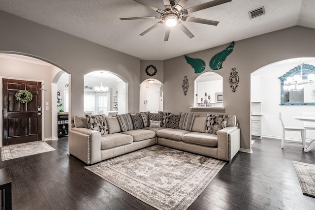 living room featuring a textured ceiling, ceiling fan with notable chandelier, dark wood-type flooring, and vaulted ceiling