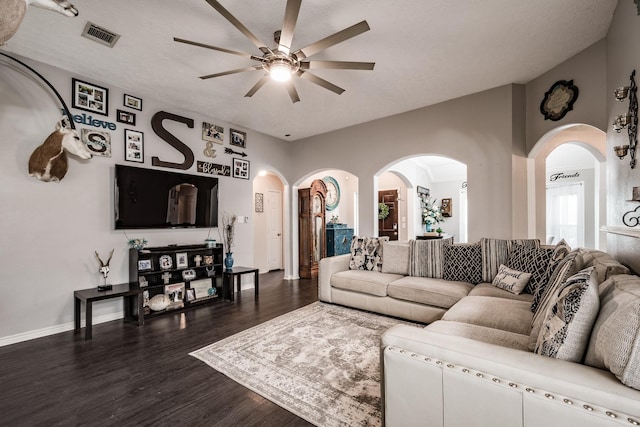 living room with ceiling fan, dark hardwood / wood-style flooring, and a textured ceiling