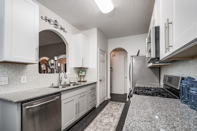 kitchen with appliances with stainless steel finishes, white cabinetry, and sink