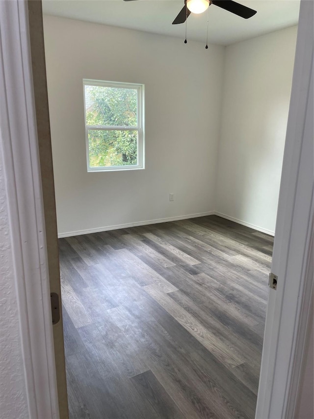 empty room with ceiling fan and dark wood-type flooring