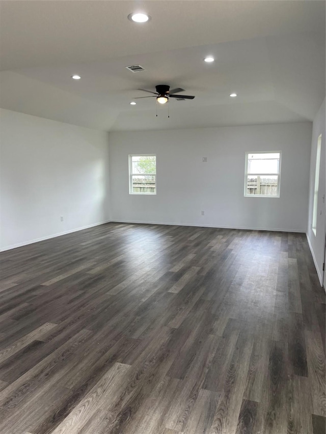 unfurnished room with ceiling fan, a healthy amount of sunlight, and dark wood-type flooring