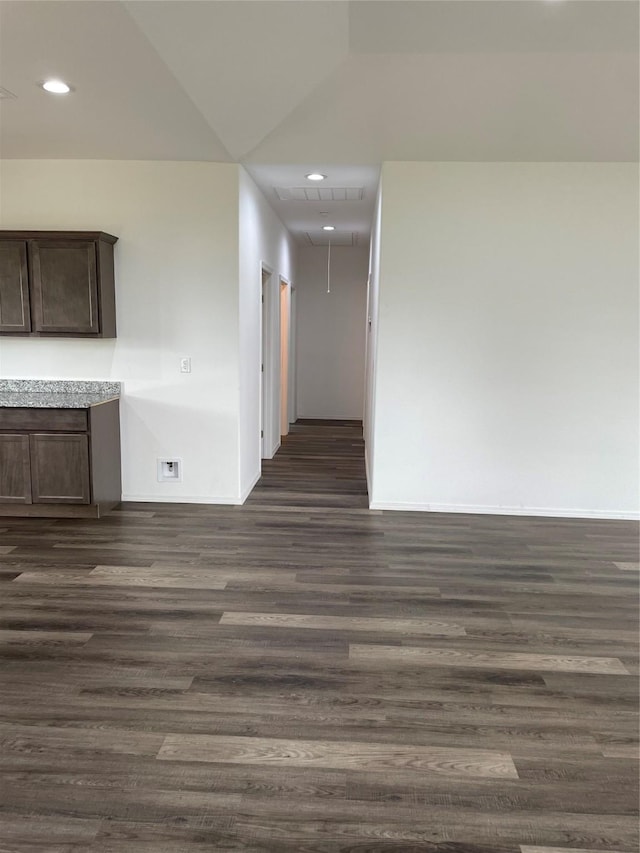 unfurnished room featuring dark wood-type flooring and vaulted ceiling