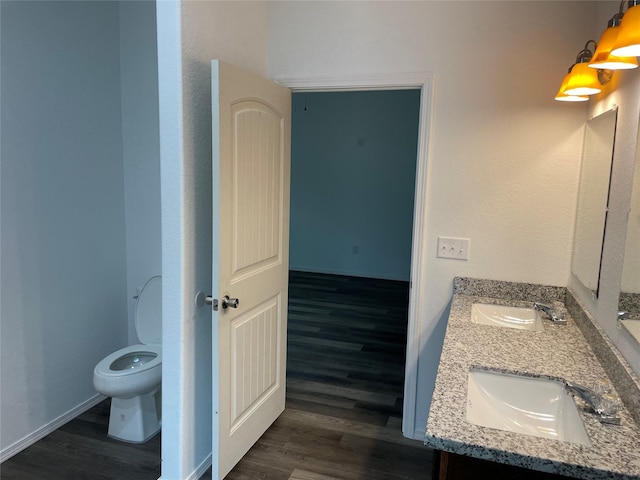 bathroom with toilet, vanity, and hardwood / wood-style flooring