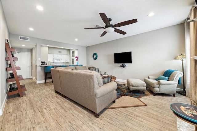 living room with ceiling fan and light wood-type flooring