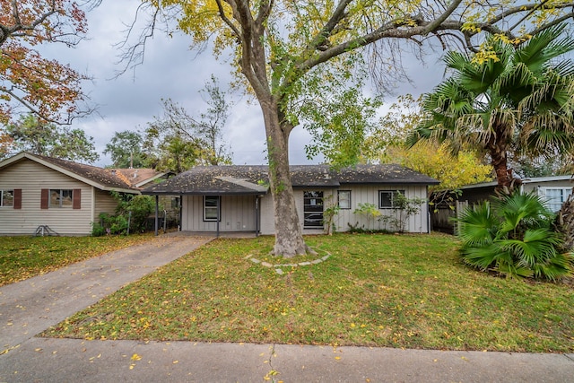 view of front of home with a front yard and a carport