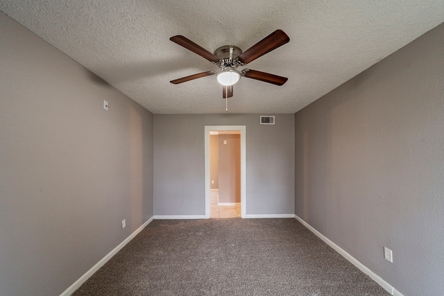 carpeted spare room featuring ceiling fan and a textured ceiling