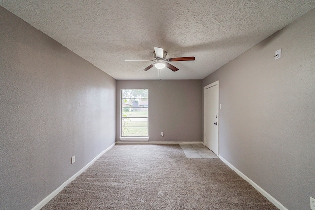 carpeted empty room with ceiling fan and a textured ceiling