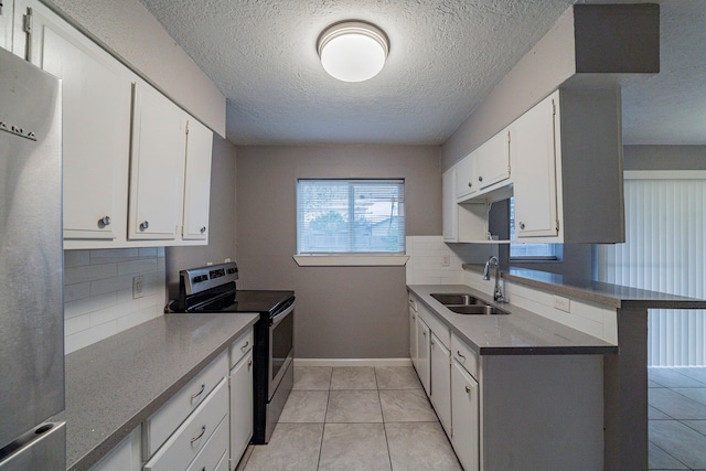 kitchen featuring appliances with stainless steel finishes, tasteful backsplash, sink, light tile patterned floors, and white cabinets