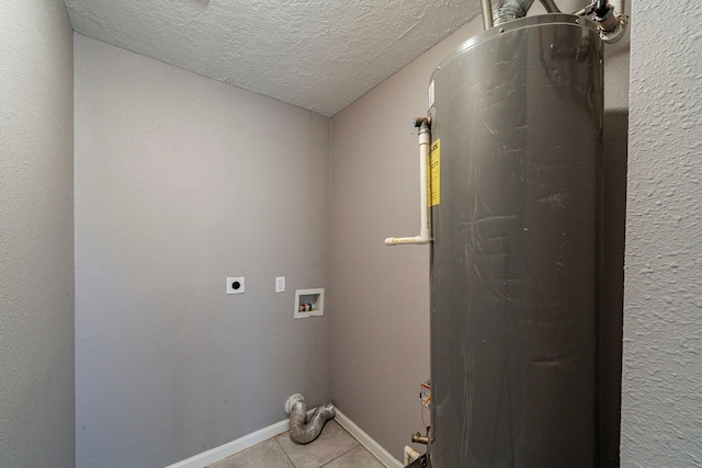 clothes washing area with gas water heater, washer hookup, a textured ceiling, hookup for an electric dryer, and light tile patterned flooring