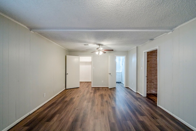 spare room featuring dark wood-type flooring, a textured ceiling, and ornamental molding