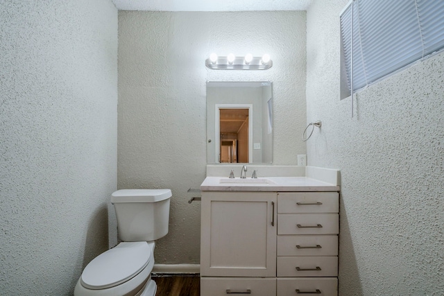 bathroom with wood-type flooring, vanity, and toilet