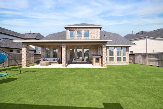 rear view of house featuring outdoor lounge area, a patio, and a lawn