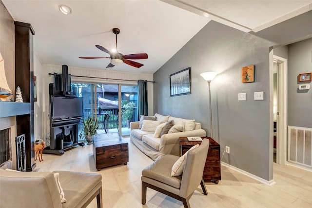 living room with light wood-type flooring, vaulted ceiling, and ceiling fan