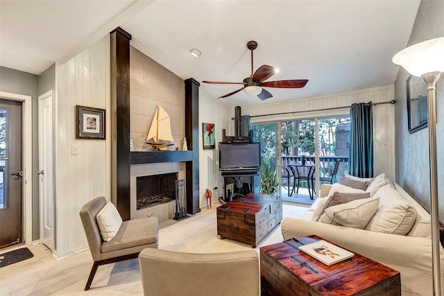 living room featuring ceiling fan, light hardwood / wood-style flooring, a healthy amount of sunlight, and lofted ceiling