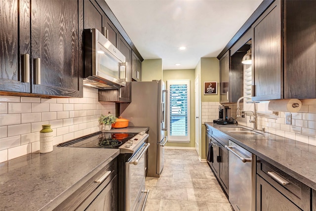 kitchen with tasteful backsplash, sink, dark brown cabinets, and appliances with stainless steel finishes