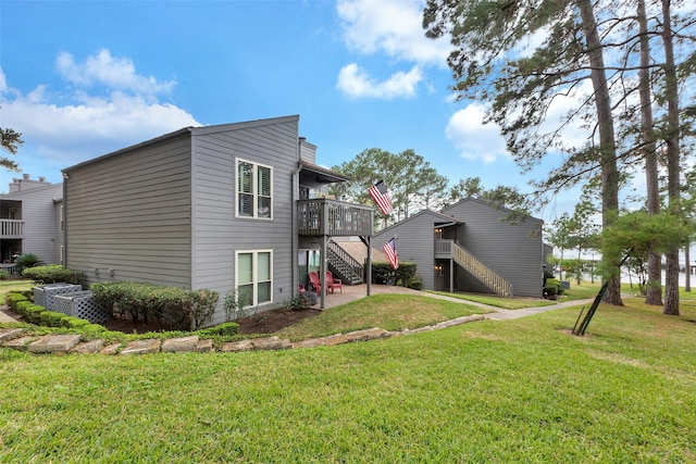 rear view of house with a deck and a lawn