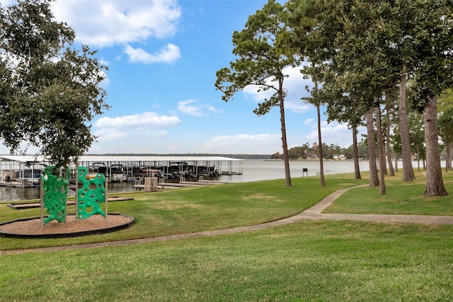 view of property's community with a lawn, a boat dock, and a water view