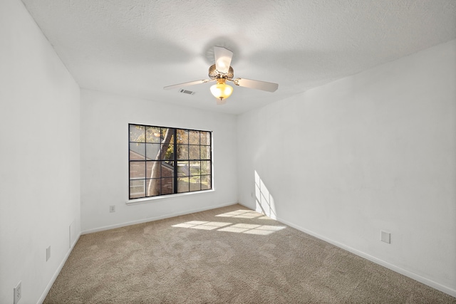 carpeted spare room with ceiling fan and a textured ceiling