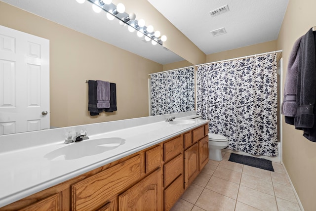 bathroom featuring vanity, tile patterned floors, toilet, a textured ceiling, and curtained shower