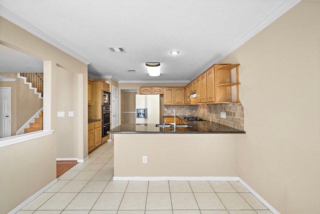 kitchen featuring kitchen peninsula, sink, dark stone countertops, white fridge with ice dispenser, and light tile patterned flooring