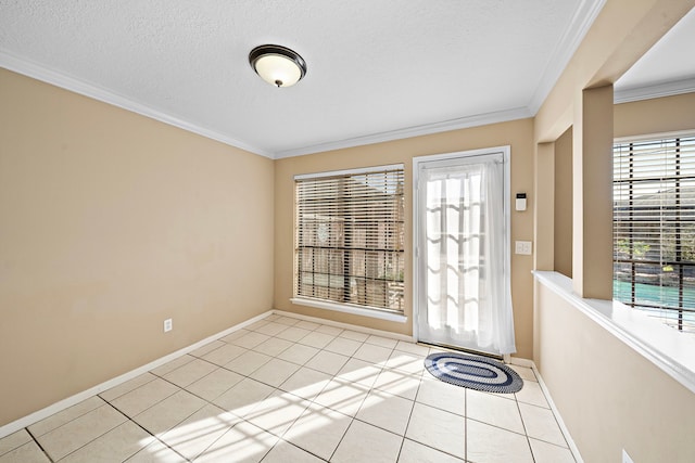 foyer entrance with a textured ceiling, ornamental molding, and light tile patterned flooring