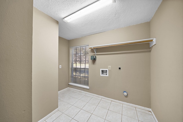 laundry room with electric dryer hookup, light tile patterned floors, washer hookup, and a textured ceiling