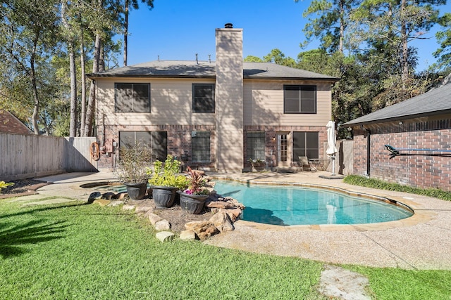 back of property featuring a yard, a fenced in pool, and a patio area