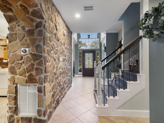 entryway featuring light tile patterned floors, crown molding, and washer / clothes dryer