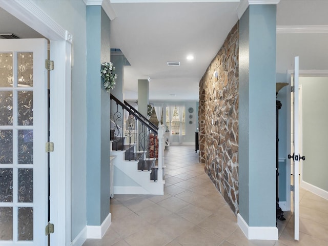 tiled foyer entrance featuring crown molding