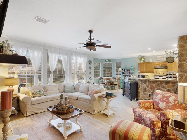 tiled living room featuring ceiling fan and ornamental molding