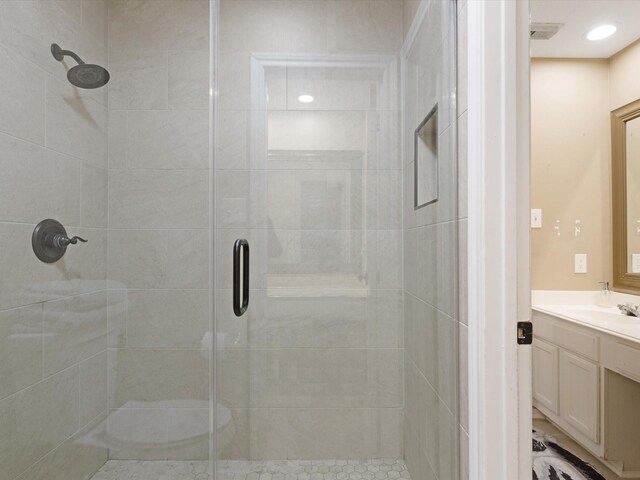 bathroom with a shower with door and vanity