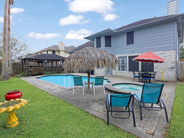 view of pool with a gazebo, a yard, an in ground hot tub, and a patio