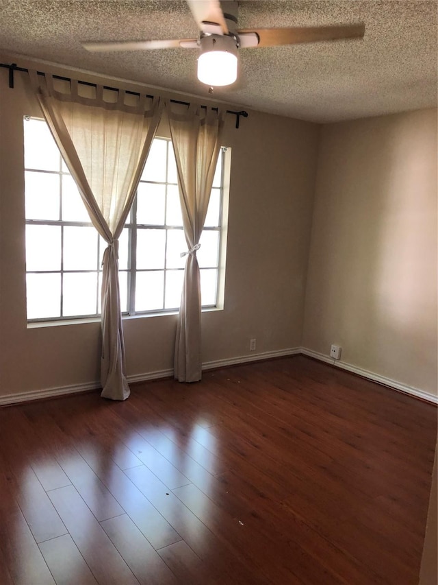 unfurnished room with a textured ceiling, dark hardwood / wood-style flooring, and plenty of natural light