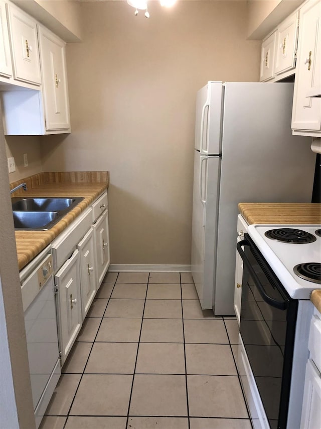 kitchen with white cabinets, white appliances, sink, and light tile patterned flooring