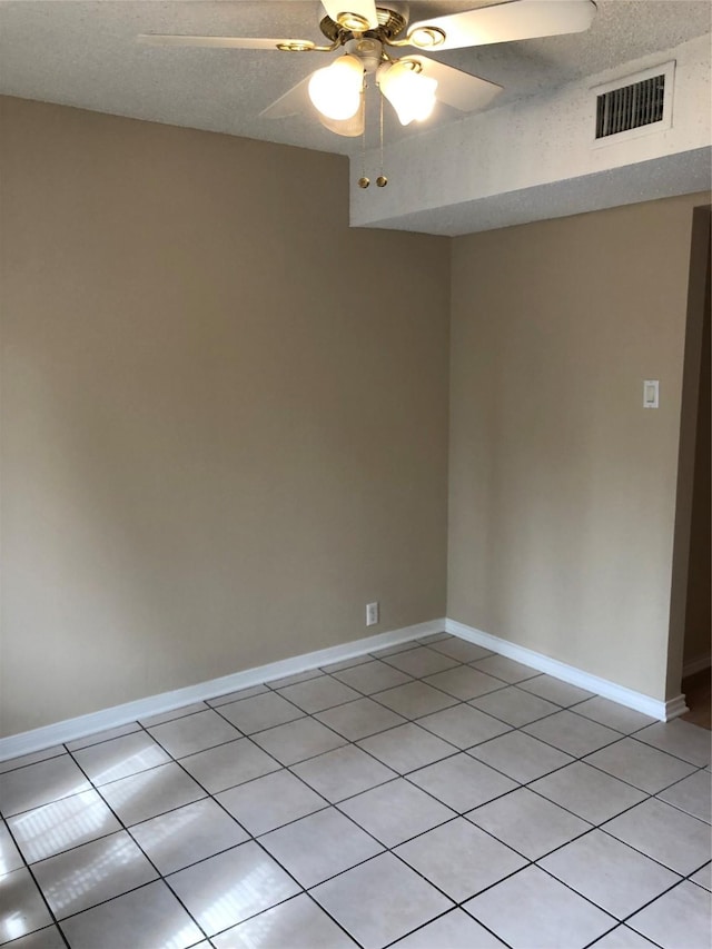 unfurnished room featuring a textured ceiling, ceiling fan, and light tile patterned flooring