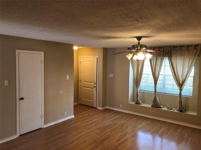 unfurnished room featuring hardwood / wood-style floors, ceiling fan, and a textured ceiling