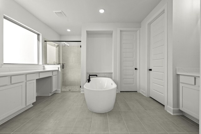 bathroom featuring tile patterned flooring, vanity, and shower with separate bathtub