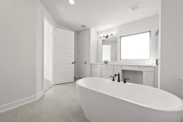 bathroom featuring vanity, tile patterned floors, and a tub