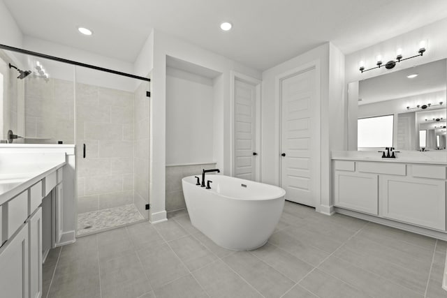 bathroom featuring tile patterned floors, vanity, separate shower and tub, and tile walls