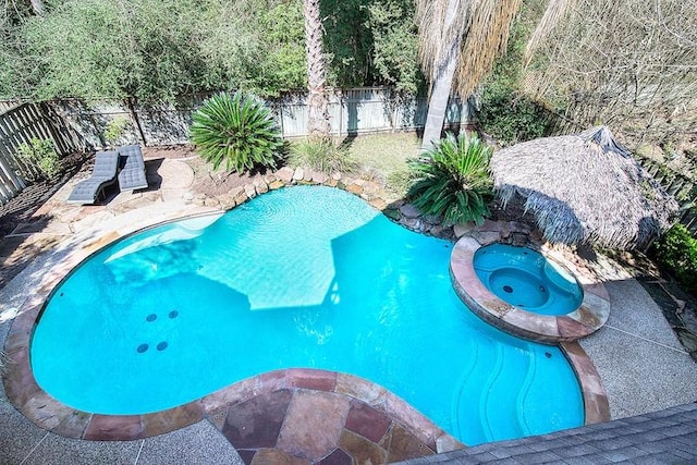 view of pool featuring an in ground hot tub