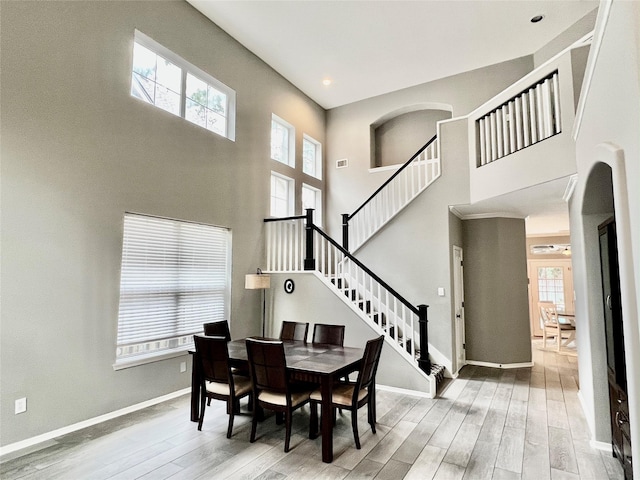 dining space featuring light hardwood / wood-style floors and a high ceiling