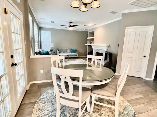 dining space featuring hardwood / wood-style flooring, ceiling fan with notable chandelier, ornamental molding, and built in shelves