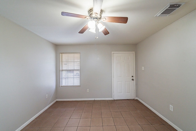 spare room featuring tile patterned floors and ceiling fan