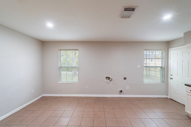 tiled empty room featuring plenty of natural light