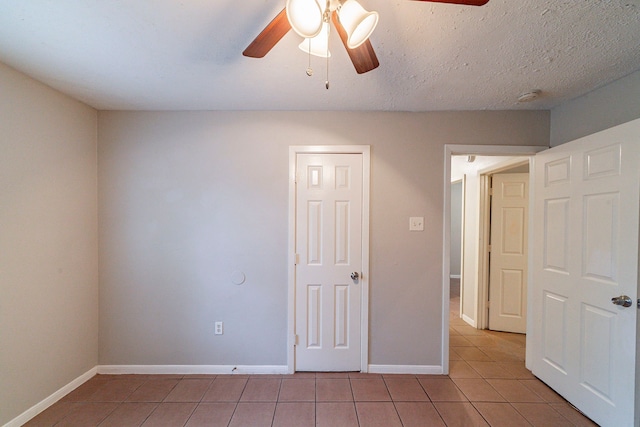 unfurnished bedroom with a textured ceiling, ceiling fan, and light tile patterned flooring