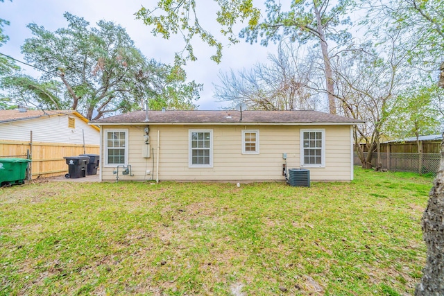 rear view of property featuring a yard and cooling unit