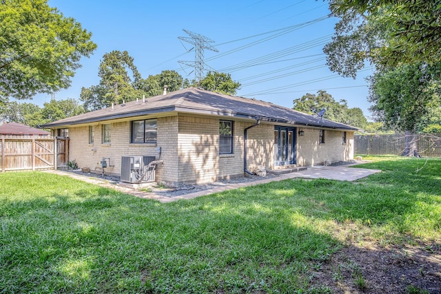 back of property with a lawn, a patio area, and central air condition unit